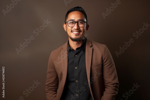Portrait of a Indonesian man in his 30s in an abstract background wearing a chic cardigan © Hanne Bauer