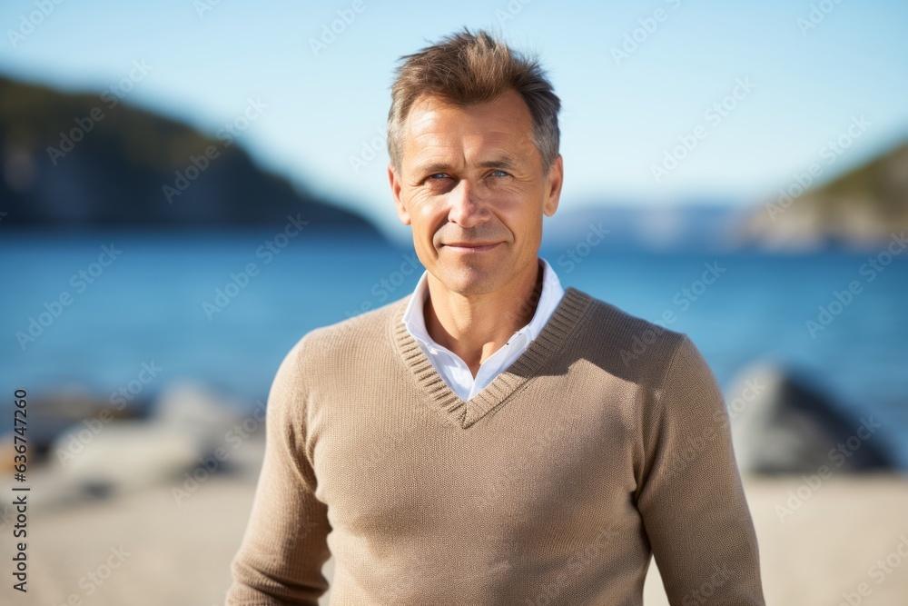 Portrait of handsome mature man on the beach, looking at camera