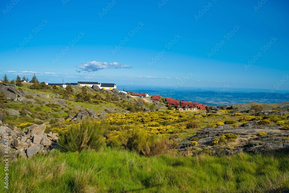 Scenic view of houses perched atop a lush, green mountain range