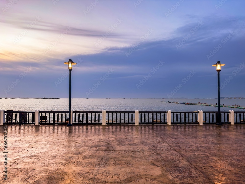 the streetlight and benches near the water and a pier