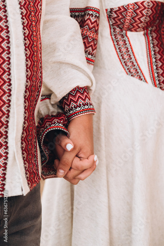 Hands of bride and groom on traditional ukrainian clothe