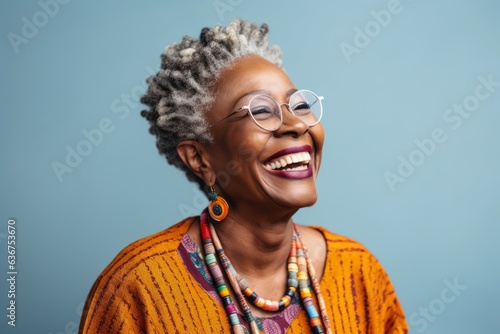 Portrait of a Nigerian woman in her 60s in an abstract background wearing a chic cardigan