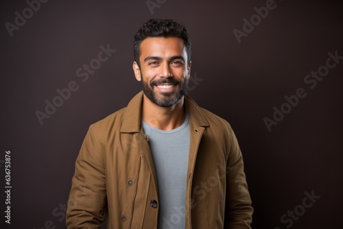 Portrait of a Saudi Arabian man in his 30s in an abstract background wearing a chic cardigan © Hanne Bauer