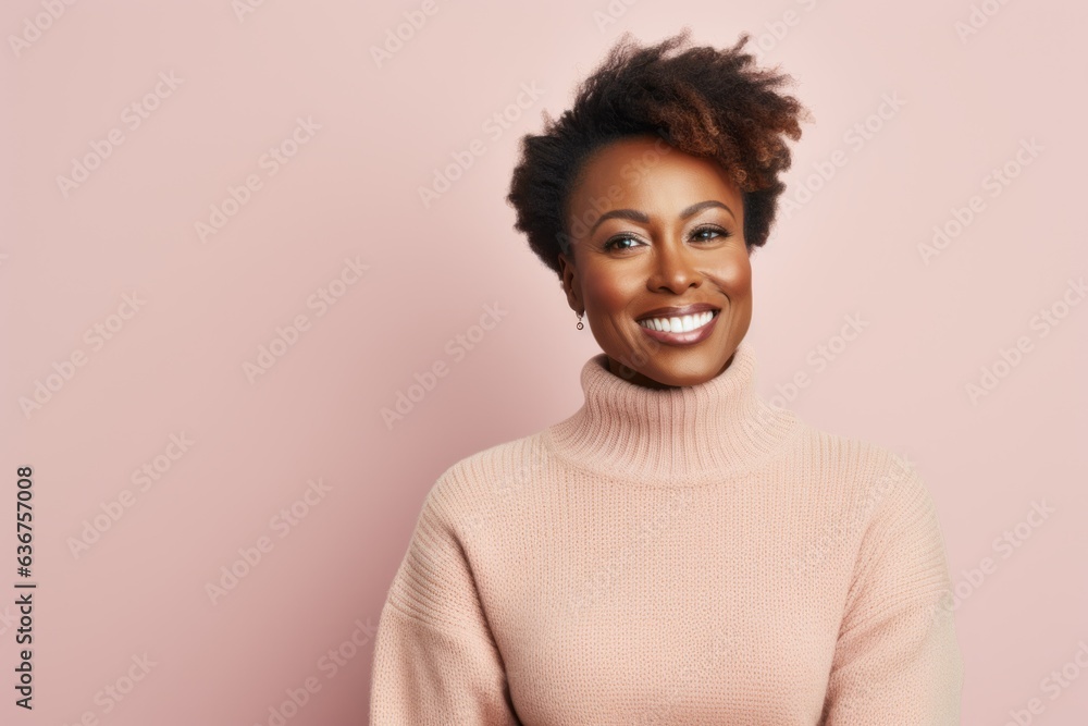 Fototapeta premium Portrait of a Nigerian woman in her 40s in a pastel or soft colors background wearing a cozy sweater