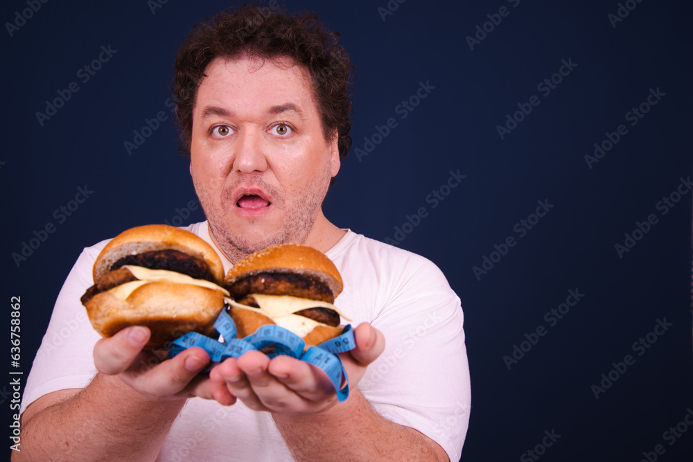 Funny fat man on a diet eats hamburgers. Funny fat man on a diet eats hamburgers.