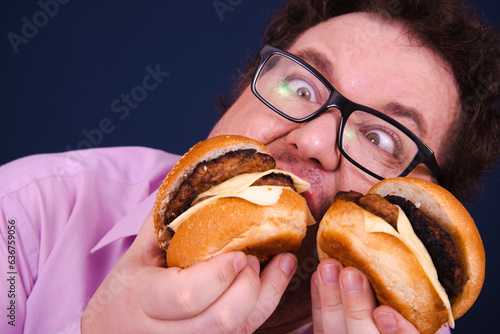 Funny fat man on a diet eats hamburgers.