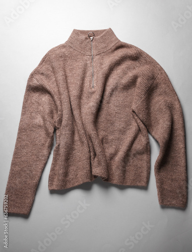Brown sweater on a gray background. Top view. Fashion concept
