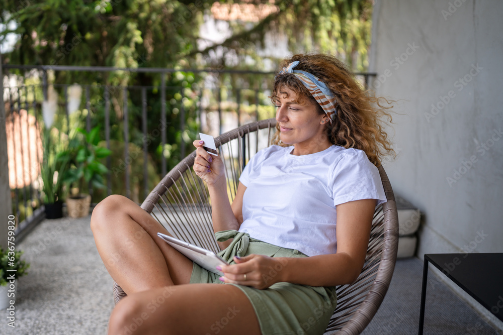 One woman shopping online hold credit card and digital tablet One woman shopping online hold credit card and digital tablet
