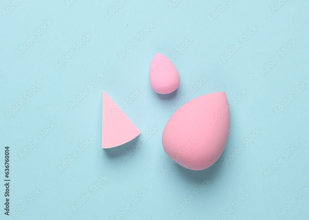 Pink make-up puffs on a blue background. Beauty concept