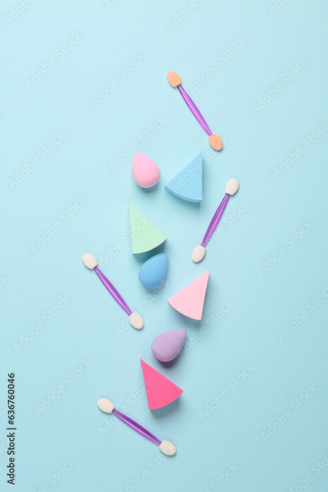 Make-up sponge, cosmetic blenders and applicators for makeup on blue background. Beauty products. Top view. Flat lay Make-up sponge, cosmetic blenders and applicators for makeup on blue background. Beauty products. Top view. Flat lay