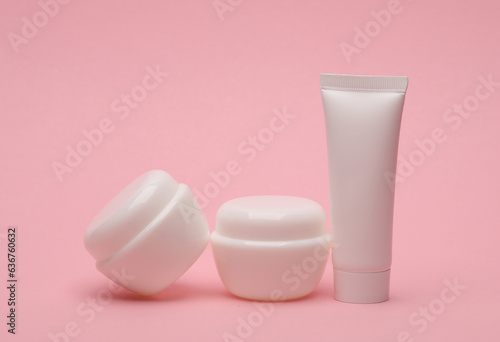 White blank cream tube and jars on pink background. Template for design, mockup. Beauty concept
