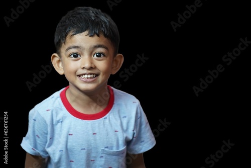 a child in a t-shirt smiling at the camera photo