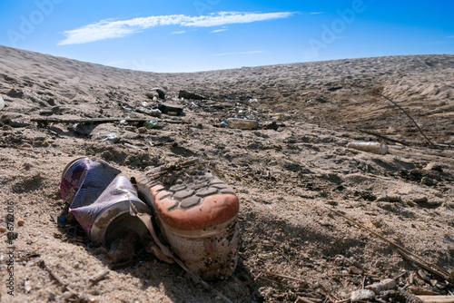 Plastic bottles and other garbage washed up on beach in Portugal. Illustrating problem of plastic pollution. Low angle.