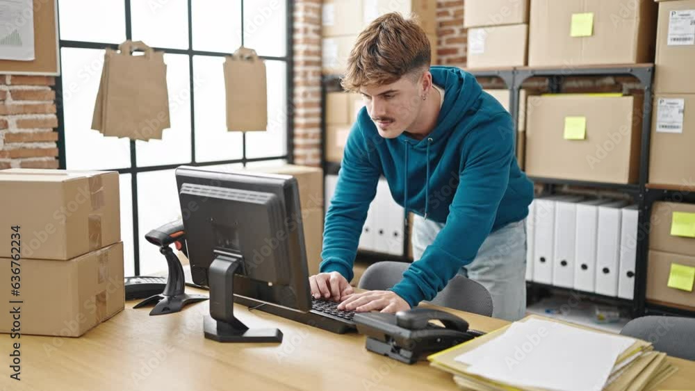 Young hispanic man ecommerce business worker using computer standing at office Young hispanic man ecommerce business worker using computer standing at office