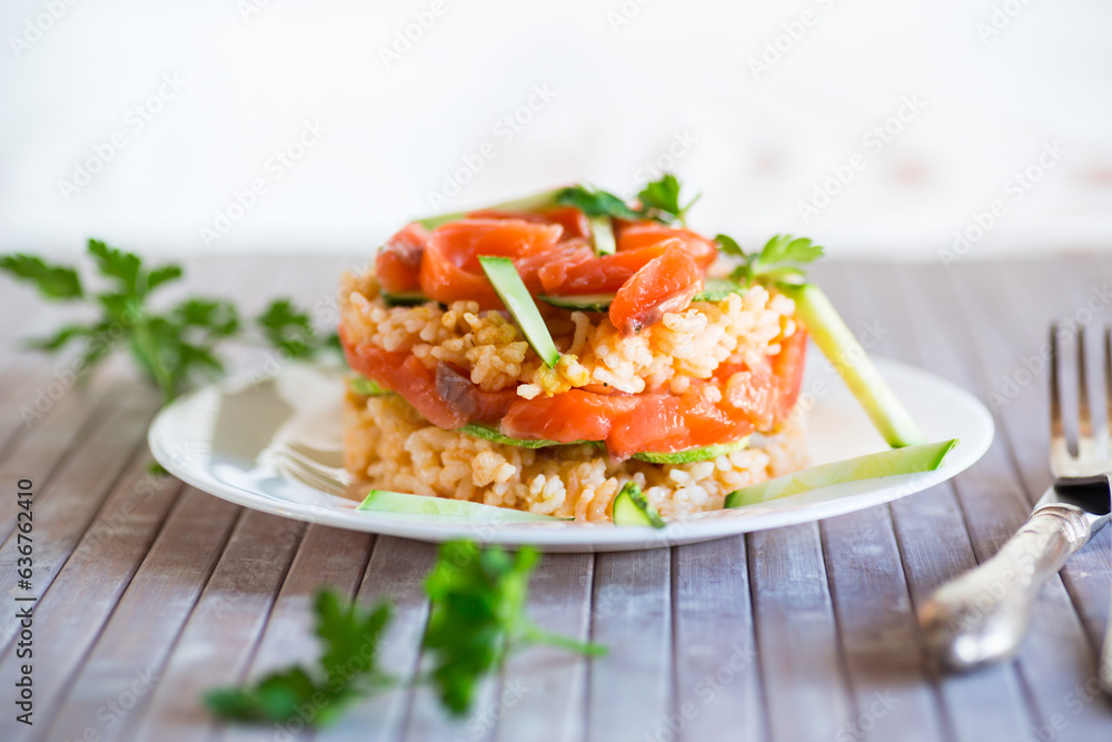 Boiled white rice with salted red fish, cucumbers and other vegetables with herbs in a plate. Boiled white rice with salted red fish, cucumbers and other vegetables with herbs in a plate.