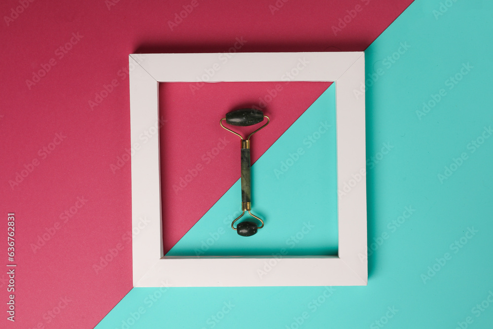 Jade massage roller in white frame on pink blue background. Creative layout. Beauty concept. Minimalism Jade massage roller in white frame on pink blue background. Creative layout. Beauty concept. Minimalism