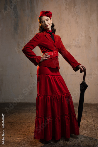 Mary Poppins. A stylish lady in a red old-fashioned suit with a hat and a lace umbrella photo