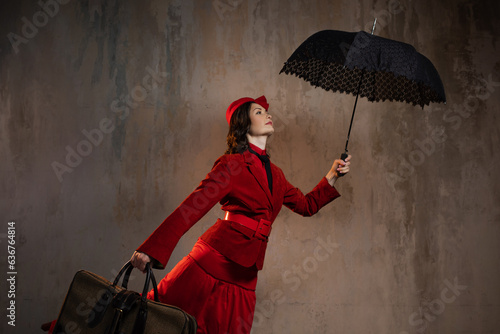 Mary Poppins. A stylish lady in a red old-fashioned suit with a hat and a lace umbrella photo