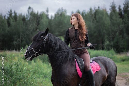 Equestrian sports. A young woman in the saddle, a rider and her horse outdoors, riding in the woods. © Ulia Koltyrina