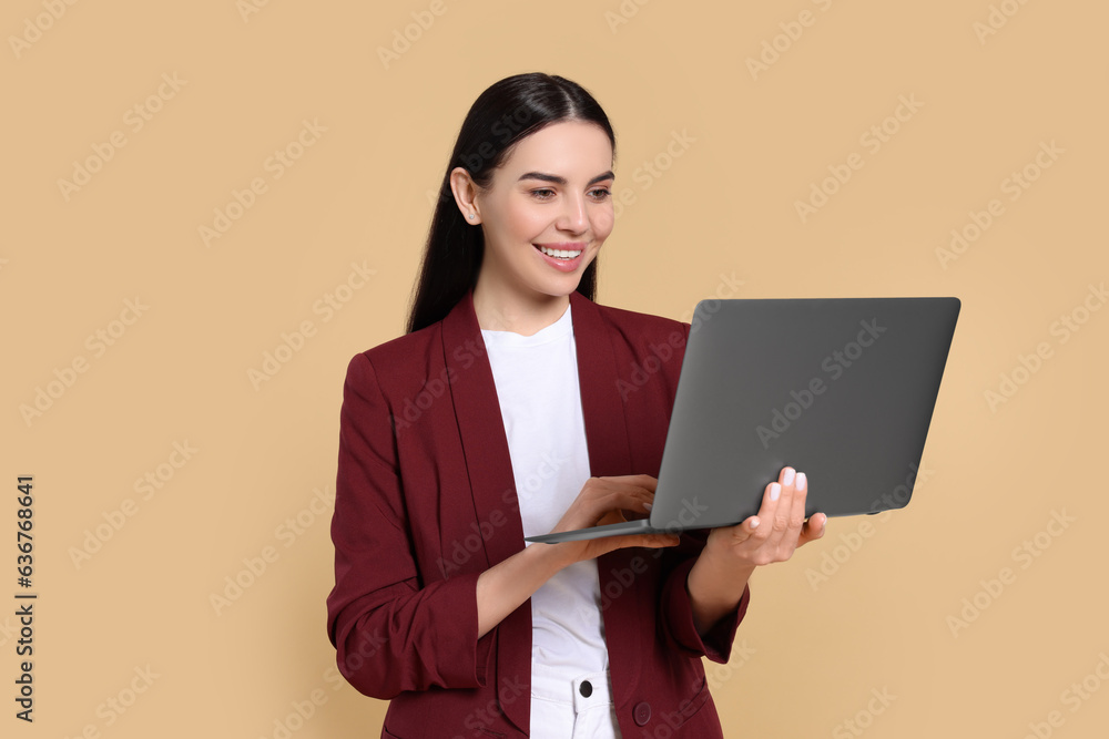 Happy woman using laptop on beige background Happy woman using laptop on beige background