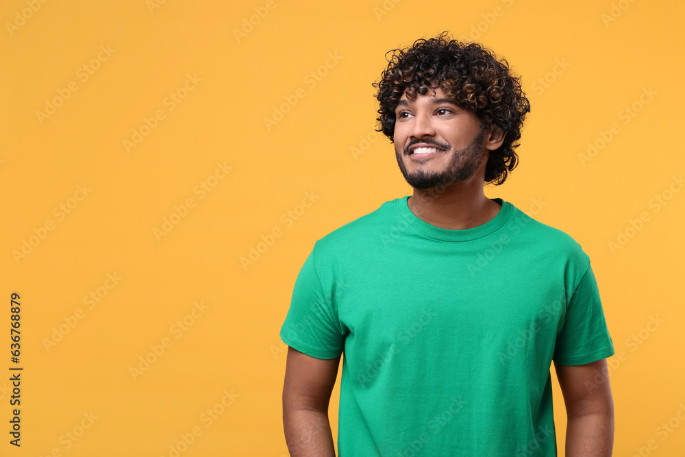 Handsome smiling man on yellow background, space for text Handsome smiling man on yellow background, space for text