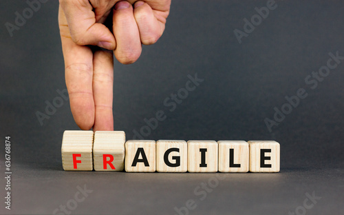 Agile or fragile symbol. Concept words Agile and Fragile on wooden cubes. Beautiful grey table grey background. Businessman hand. Business agile and fragile concept. Copy space.