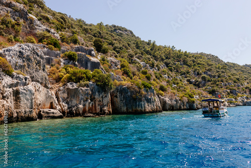 Beautiful view of the Mediterranean Sea with yachts. Picturesque landscape of blue ocean and green mountains on a sunny summer day. The sunken city of Kekova, Türkiye - 28 July 2023