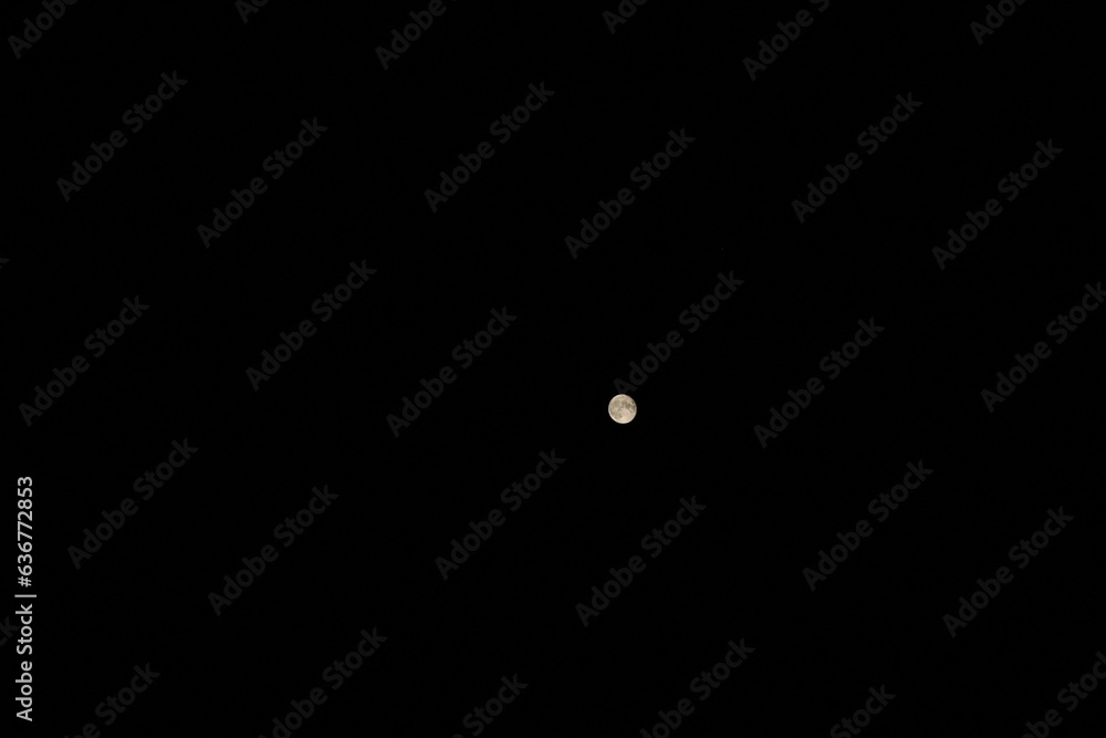 Beautiful scene of the full moon gleaming in the cloudless night sky Beautiful scene of the full moon gleaming in the cloudless night sky