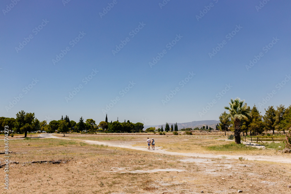 Obraz premium Old dilapidated architecture of Turkey. Ruins of an ancient city. Journey to the old city. Mountain landscape. Ancient city of Hierapolis, Pamukkale, Türkiye - July 29, 2023