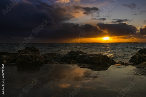 Scenic view of a rocky beach at a cloudy sunset