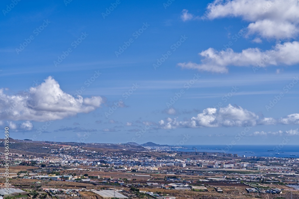 Obraz premium Aerial view of a city on the coast against the blue sea on a sunny day