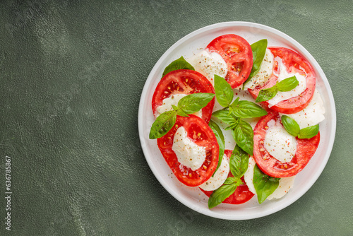 Fresh italian caprese salad with mozzarella and tomatoes on white plate. Top view. Copy space