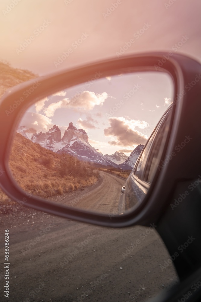 Vertical shot of a beautiful scenery of snowy mountains reflected in the car mirror in Chile