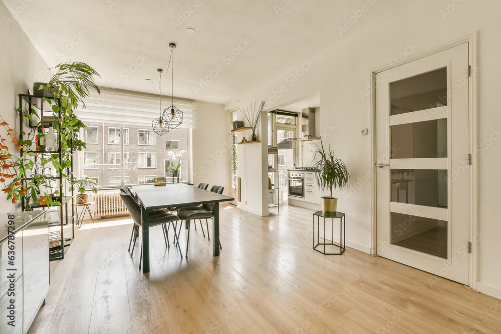 a living room with hardwood flooring and white walls there is a dining table in the room has a tv on the wall a living room with hardwood flooring and white walls there is a dining table in the room has a tv on the wall