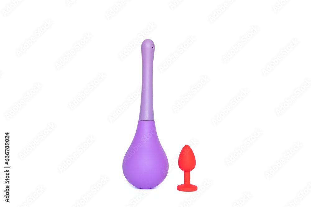 Red silicone smooth butt plug and anal douche, sex toy, on a white background. Contrast photo of anal toys, erotic toys, enema Red silicone smooth butt plug and anal douche, sex toy, on a white background. Contrast photo of anal toys, erotic toys, enema