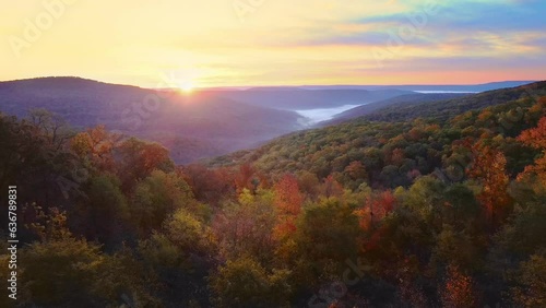 Beautiful mountain view sunrise over Ozark Mountains with foggy valley and autumn colored trees shot via drone aerial