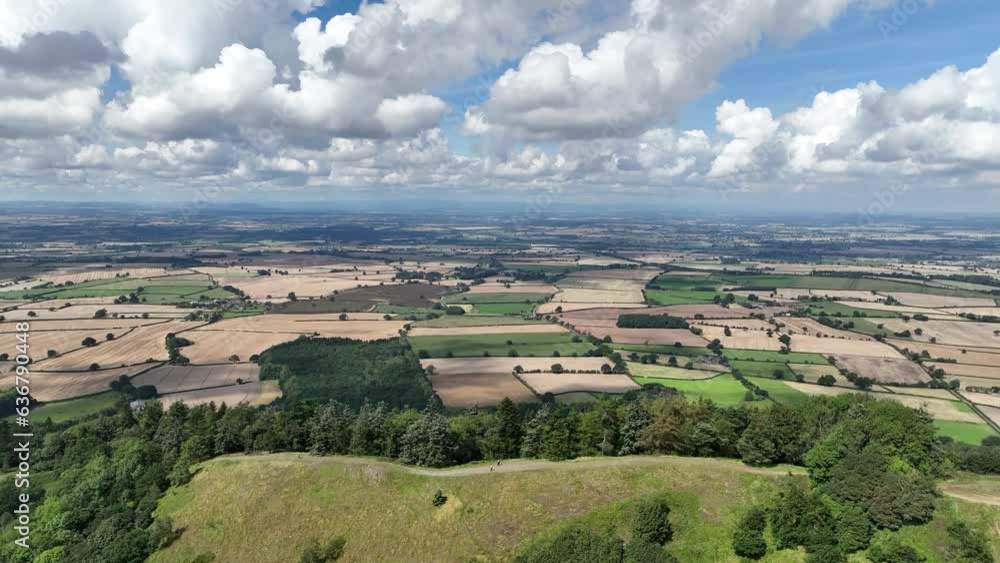 4K rising drone establishing shot revealing a green rural countryside landscape behing a large hill mountain hiking spot on a sunny day in rural england 4K rising drone establishing shot revealing a green rural countryside landscape behing a large hill mountain hiking spot on a sunny day in rural england