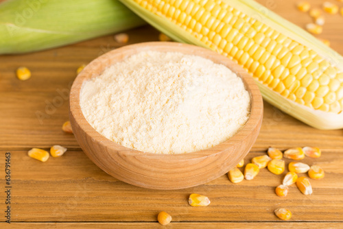 Corn flour with fresh cobs on wooden table