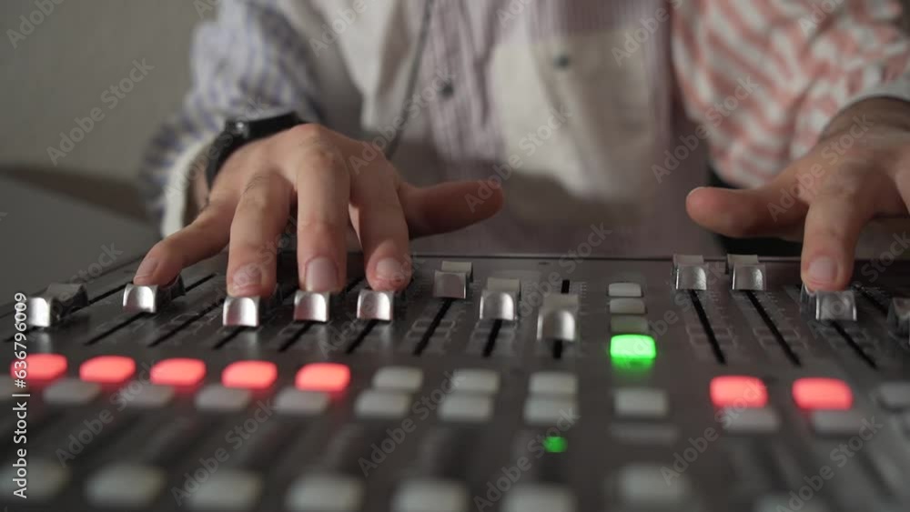 Main qui mixe des sons sur une table de mixage Main qui mixe des sons sur une table de mixage