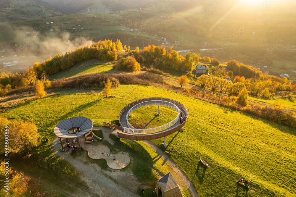 Φωτογραφία Aerial view of a wooden lookout tower in autumnal mountains at sunset in Poland
