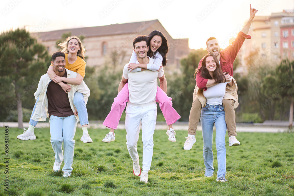 Group of funny pairs of friends piggybacking in park on sunny spring day. Three couples of cheerful multiracial young having fun outdoors. Community friendships between men and women in youth. Group of funny pairs of friends piggybacking in park on sunny spring day. Three couples of cheerful multiracial young having fun outdoors. Community friendships between men and women in youth.