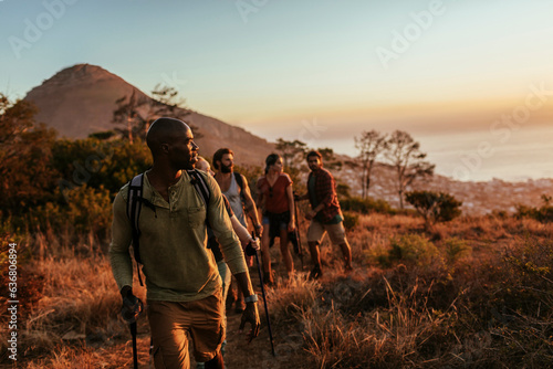 Diverse group of young friends hiking in the mountains together photo