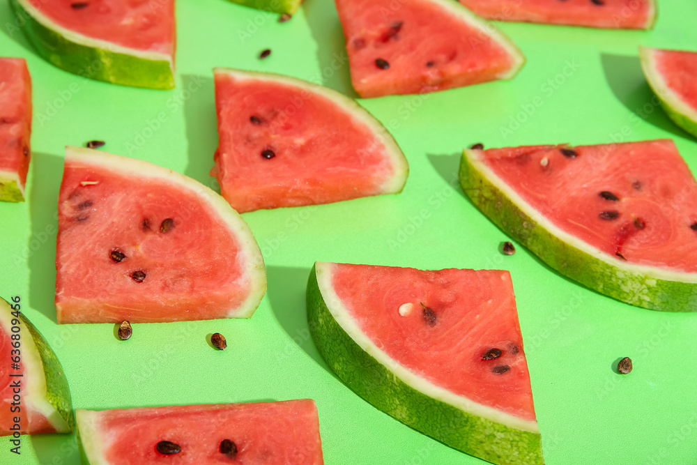 Composition with pieces of fresh ripe watermelon on green background, closeup Composition with pieces of fresh ripe watermelon on green background, closeup