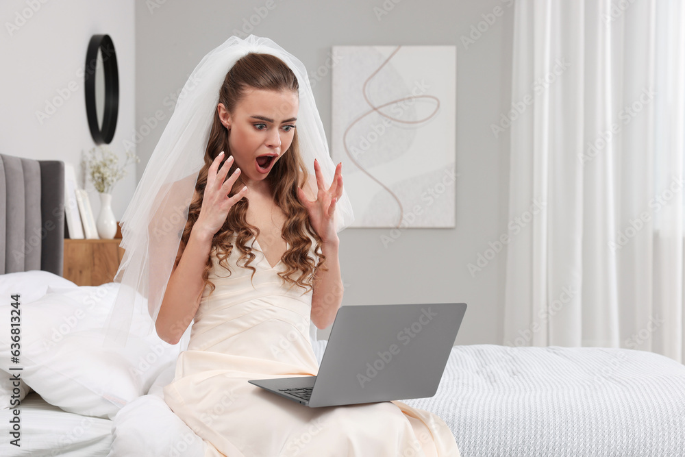 Shocked bride with laptop on bed in bedroom Shocked bride with laptop on bed in bedroom