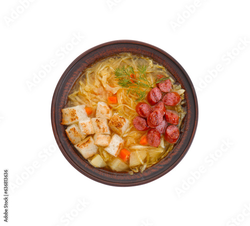 Bowl of delicious sauerkraut soup with smoked sausages, dill and croutons isolated on white, top view