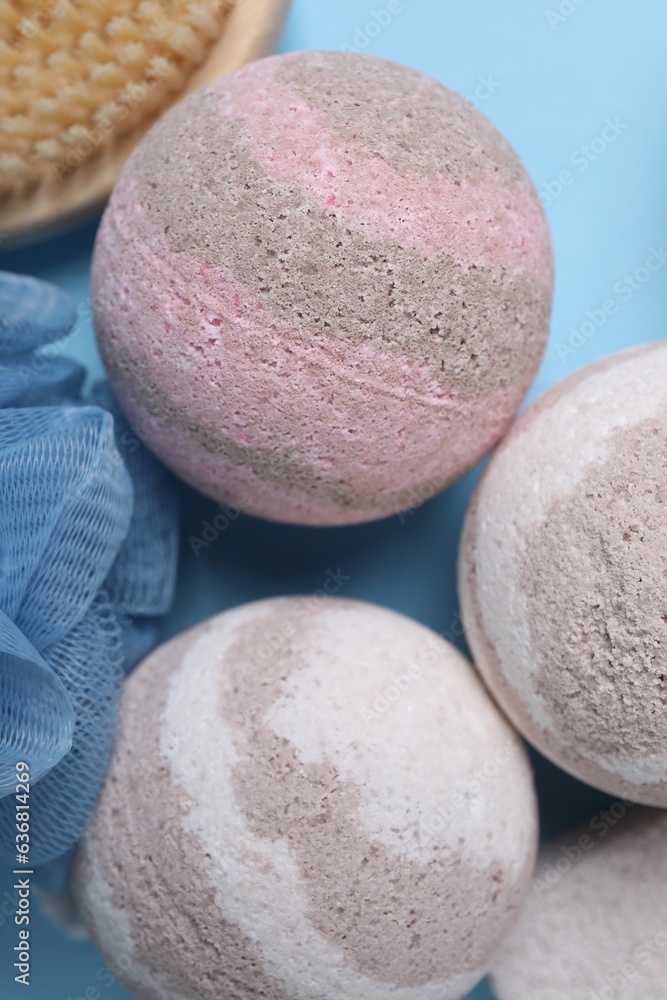 Bath bombs and massage brush on light blue background, closeup Bath bombs and massage brush on light blue background, closeup