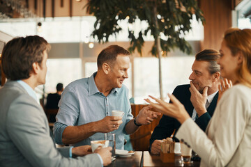 Group of business people having coffee and talking in a cafe decorated for the christmas and new year holidays