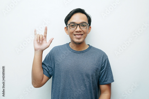 Portrait of Indonesian Asian man showing love sign language for deafness gesture. Isolated white background