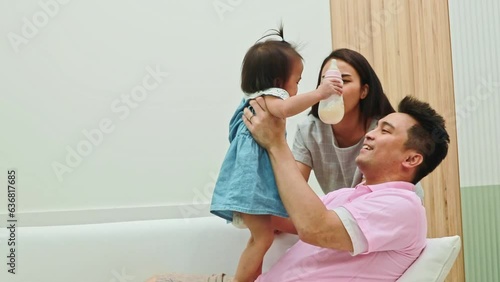 Happy family Parents who indulge their children : Parents raised their milk-hungry daughter be capricious begging with affection and persuading her to stop crying. photo