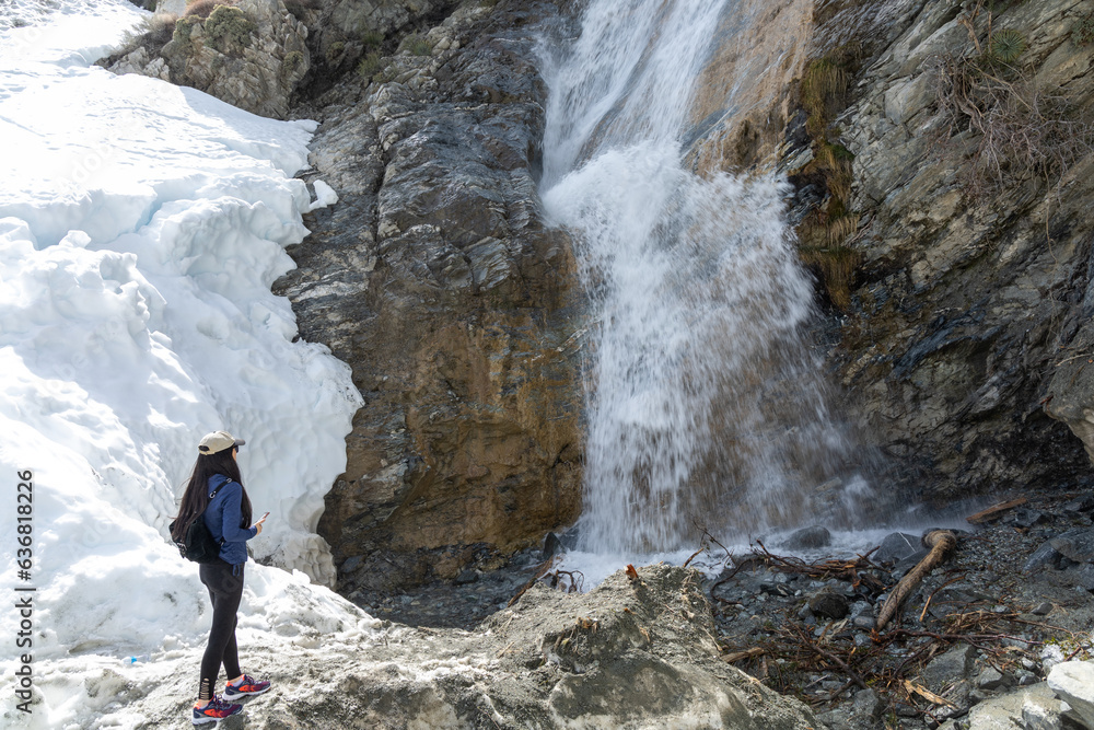 Women in the snow watching a beautiful waterfall Women in the snow watching a beautiful waterfall